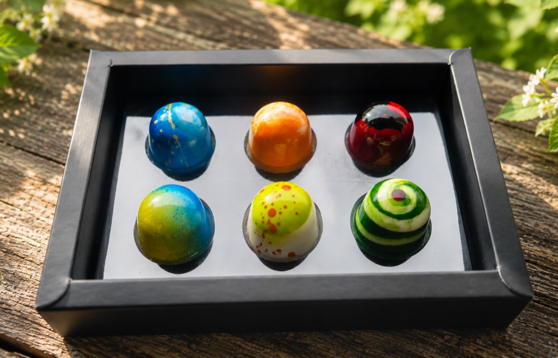 A black box of six hand-painted chocolate bonbons